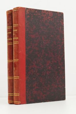 two red books sitting on top of each other on a white surface