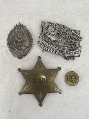 three badges and a badge are laying on a white surface