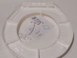 a white toilet seat with a tag attached to it