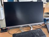 a computer monitor and keyboard on a desk in an office