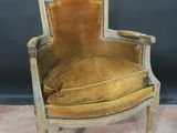 an old chair with a yellow velvet upholstered seat