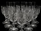 six wine glasses are lined up in a row on a black surface