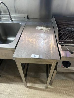 un évier en inox et une cuisinière en inox dans une cuisine
