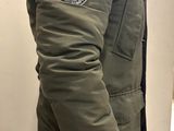 man wearing a green parka jacket with a hood and a fur collar