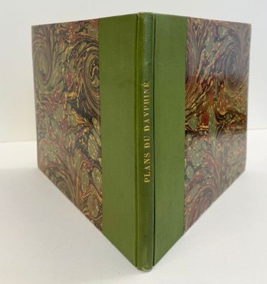 un livre posé sur une table, avec une couverture verte