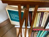 a book shelf with books on it next to a lamp