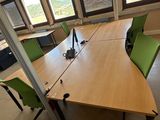 une longue table avec des chaises vertes dans un bureau