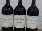 trois bouteilles de vin posées sur une table en bois