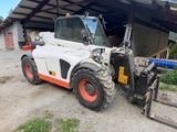 a white and orange forklift parked in front of a building