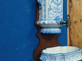 a blue and white vase on a shelf next to a blue wall