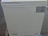 a white refrigerator sitting on a pallet in a warehouse