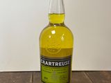 une bouteille de whisky à la Chartreuse posée sur une table en bois