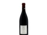the bottle of wine is sitting on a white surface