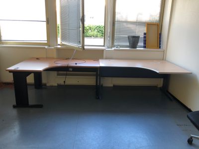 un bureau sur lequel se trouve un ordinateur, dans une pièce vide
