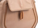 a close up of a tan purse on a white background
