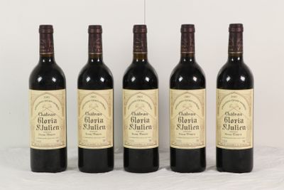 quatre bouteilles de vin rouge sont alignées sur une table