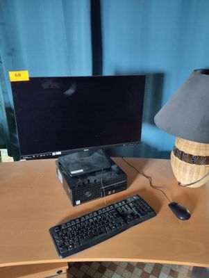 un bureau sur lequel se trouvent un ordinateur, un clavier, une souris et une lampe