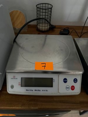 une balance posée sur une table, sur laquelle se trouve un panier