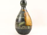 a black and yellow vase with a bird on it