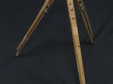 an old wooden tripod with a metal handle on a black background