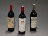 trois bouteilles de vin sont alignées les unes à côté des autres sur une surface grise