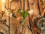 un tableau accroché au mur derrière une table sur laquelle se trouvent un vase et une bougie