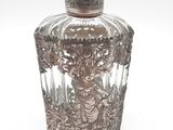 un flacon de parfum ancien en verre plaqué argent, orné d'une femme sur le bouchon