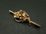 un gros plan d'une broche ornée de fleurs