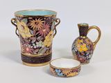 two vases and a bowl sitting next to each other