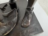 a bronze statue of a woman ' s foot and a shoe