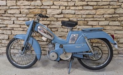 une moto bleue garée près d'un mur de pierre