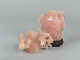 a pink vase and two small vases sitting on a table