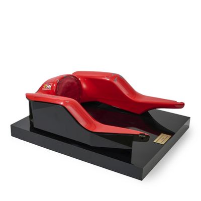 a red object on a black stand on a white background