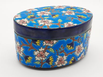 a blue tin box with a floral design on it