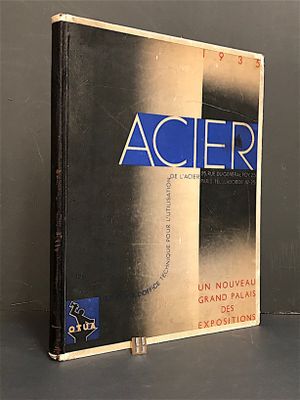 un livre posé sur une table devant un mur gris