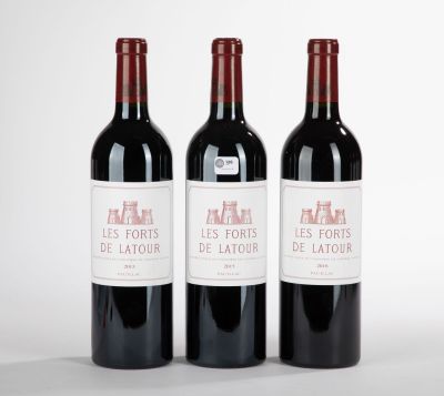trois bouteilles de vin rouge posées côte à côte sur une table