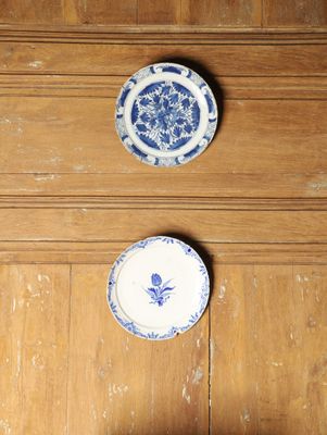 trois assiettes bleues et blanches posées sur un plancher en bois