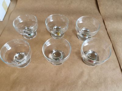 six verres vides posés sur une nappe marron