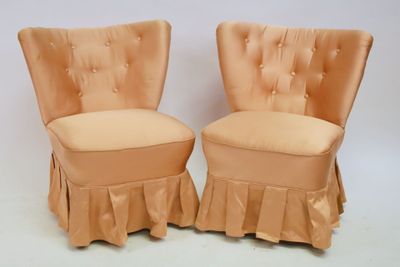 pair of orange velvet chairs with ruffled skirt
