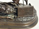 a bronze statue of a dog and a cat on a table