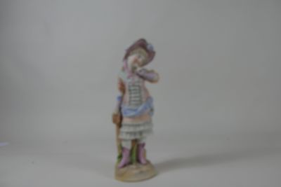 une figurine représentant une femme portant un chapeau et une robe