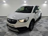L'Opel blanche est garée dans une pièce au sol carrelé.