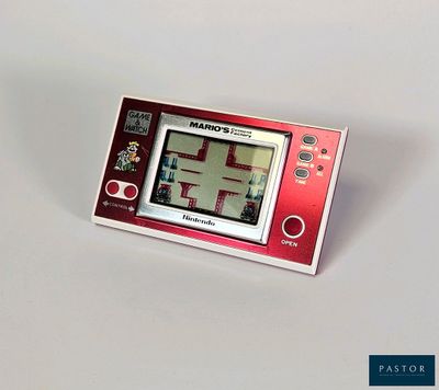 un jeu électronique rouge et blanc posé sur une table blanche