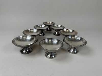 six silver plated candlesticks in a circle on a white surface