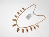 a close up of a gold necklace with flowers on it