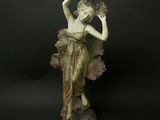 statue d'une femme tenant un éventail sur fond noir