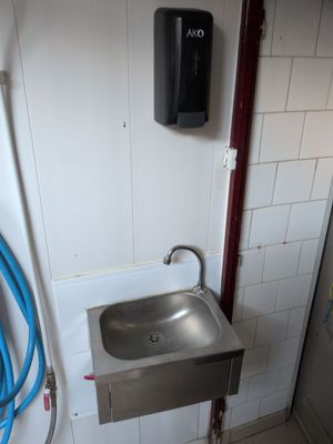 a bathroom with a sink and a hose on the wall