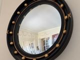 a round mirror hanging on the wall in a room