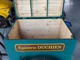 a green cart with a wooden box on the back of it