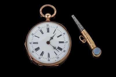 une montre de poche et un stylo sur fond noir
